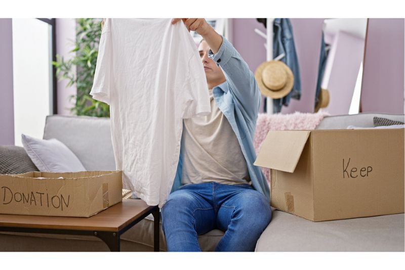 Frau mistet Kleidung aus als Umzugsvorbereitung