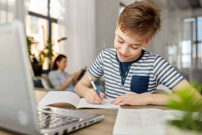 Hausaufgaben Routine Junge macht Hausaufgaben am Tisch